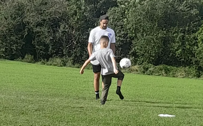 GYM Mentor playing football with mentee